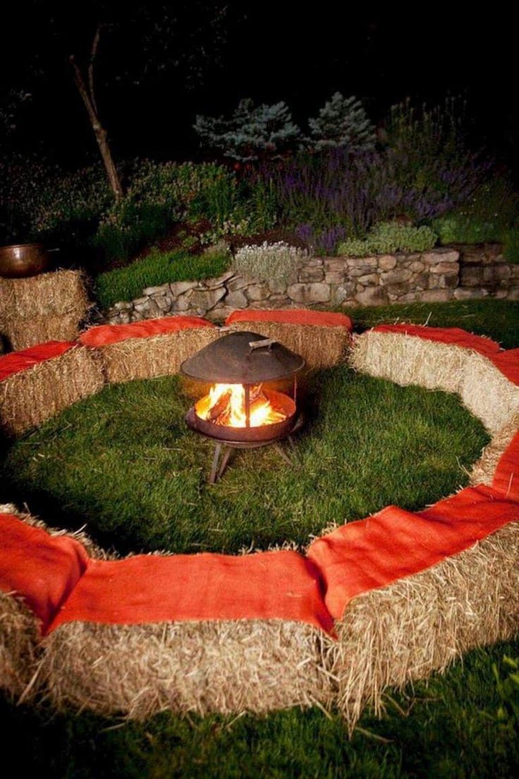 a fire pit in the middle of some grass