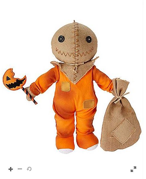 an orange stuffed animal with a pumpkin in it's hand and a bag on the other side