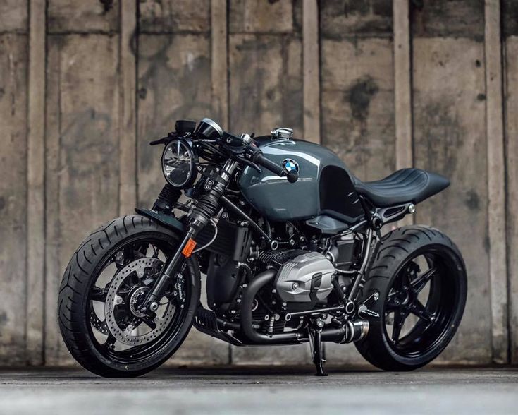 a motorcycle parked in front of a wooden wall