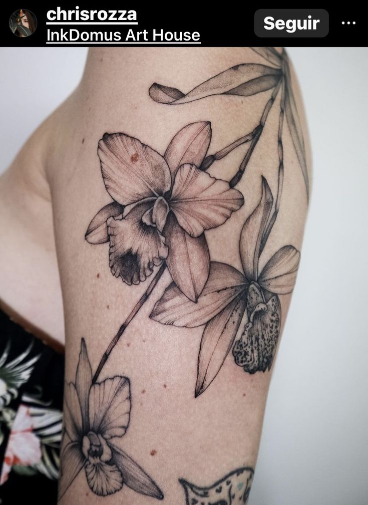 a woman's arm with flowers on it, and the words tattoos art house