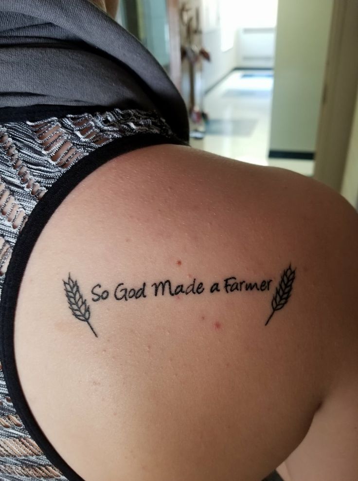 the back of a woman's shoulder with a tattoo saying, so god made a farmer