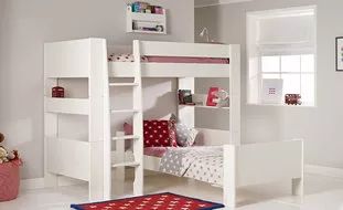 a white bunk bed sitting next to a red rug