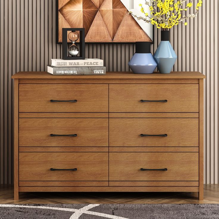 a wooden dresser with two vases on top of it