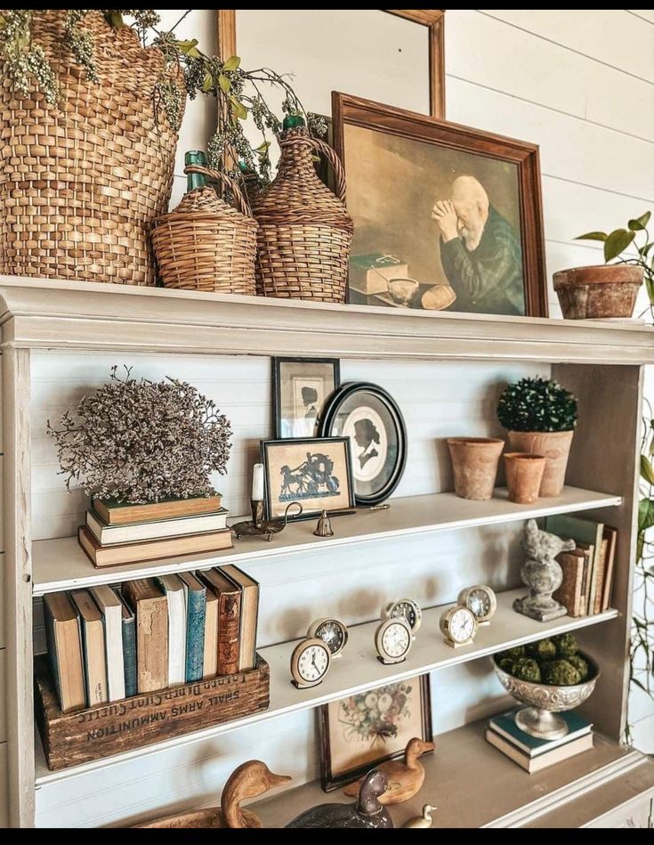 an old book shelf with books and pictures on it, along with other decorative items