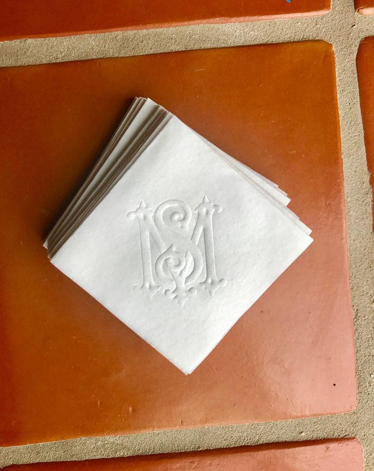 a white napkin sitting on top of a brown tile floor