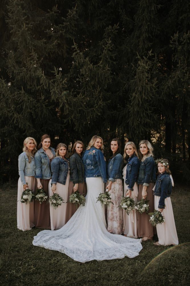 a group of women standing next to each other in front of some trees and grass