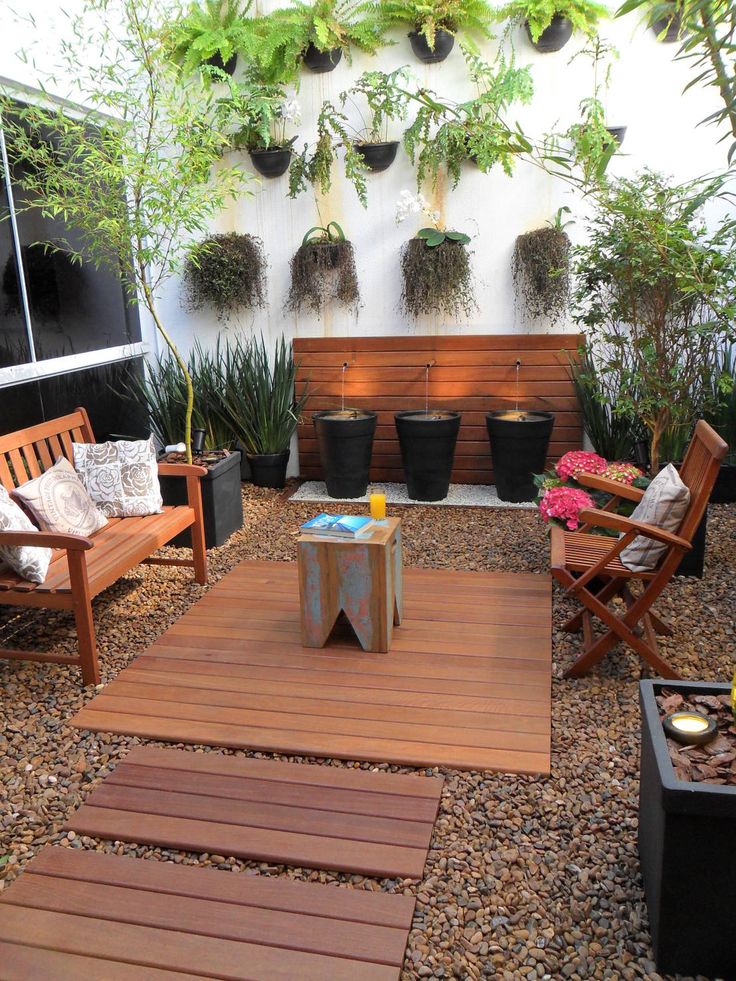 an outdoor patio with wooden benches and potted plants