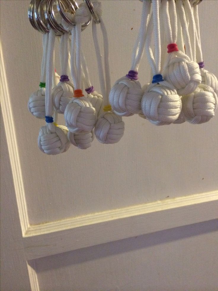 several white balls are hanging from a hook on a door handle and some metal rings