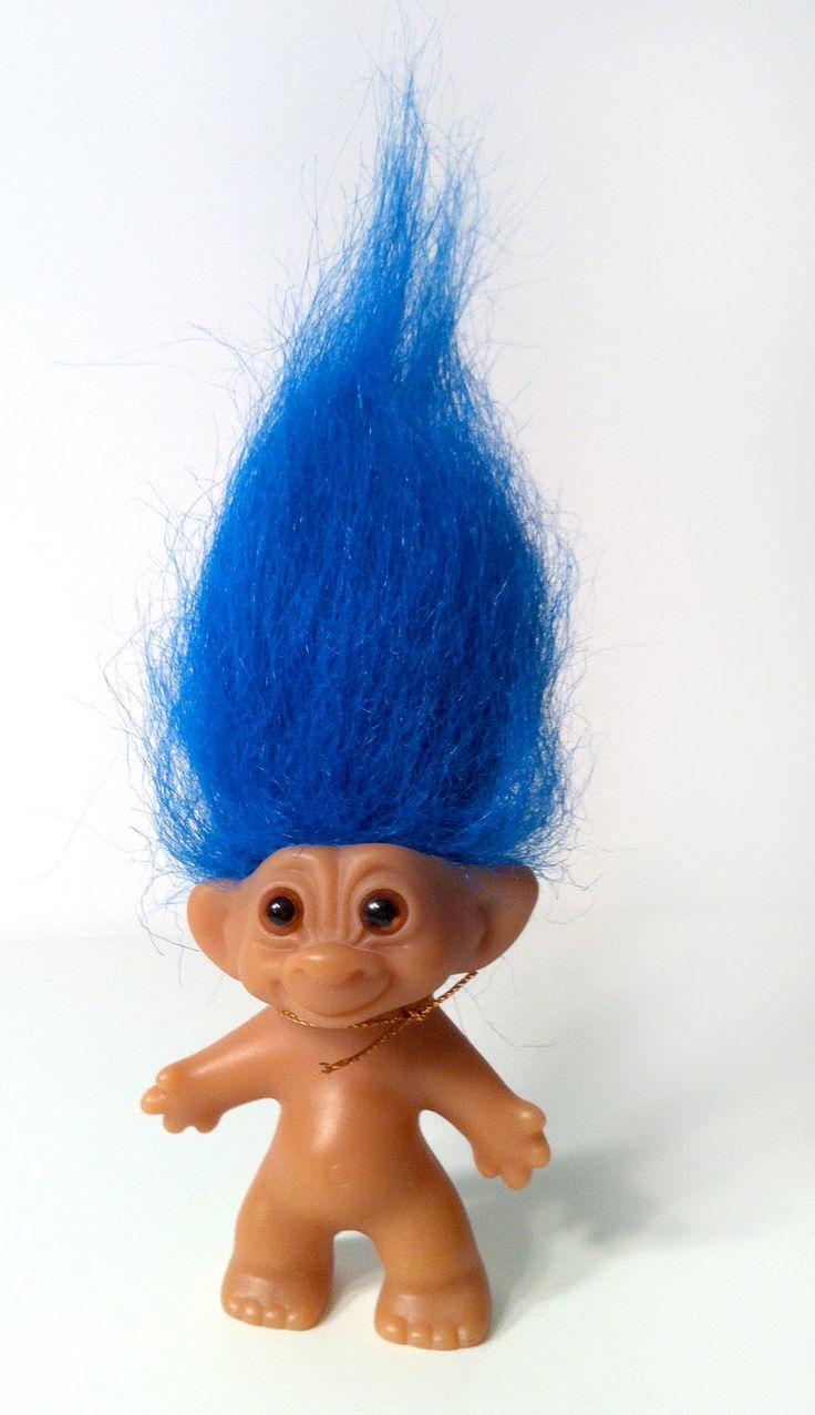 a toy troll with blue hair on it's head