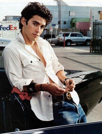 a young man sitting on the hood of a car