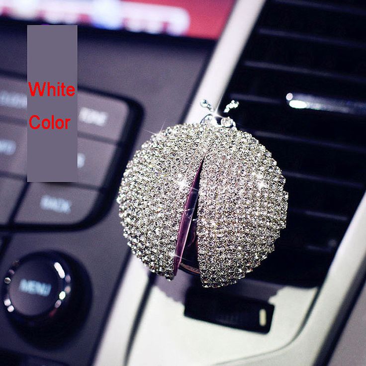 the interior of a car with a white color keychain covered in crystal balls