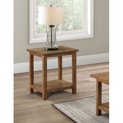 a wooden table with a lamp on top of it next to a window and rug