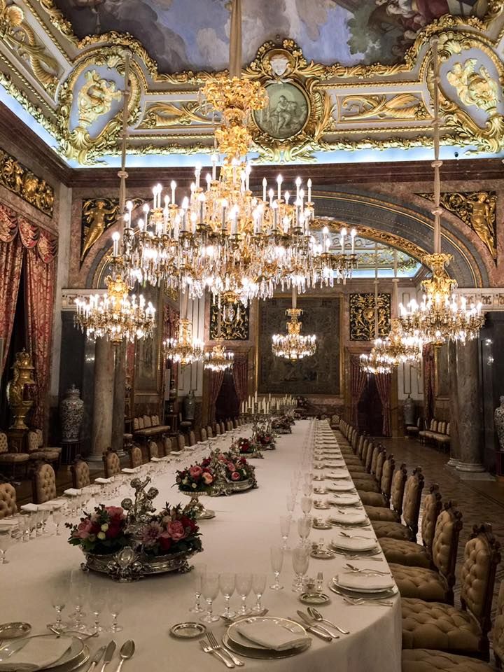 a large dining room with chandeliers and tables set up for a formal function