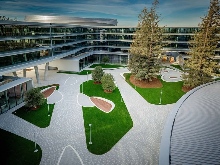 an aerial view of the outside of a building with grass and trees in front of it