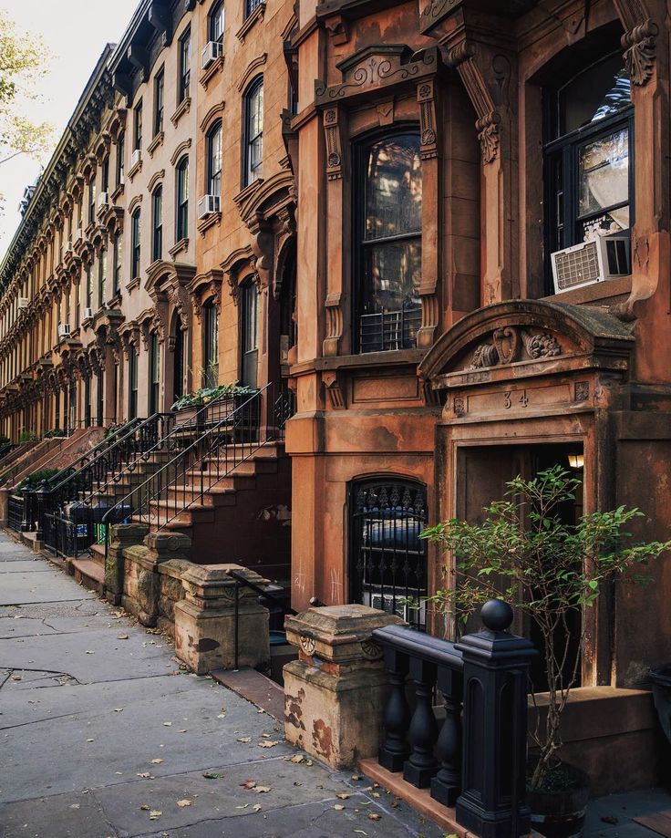 an old building with many windows and balconies on the side walk in new york city