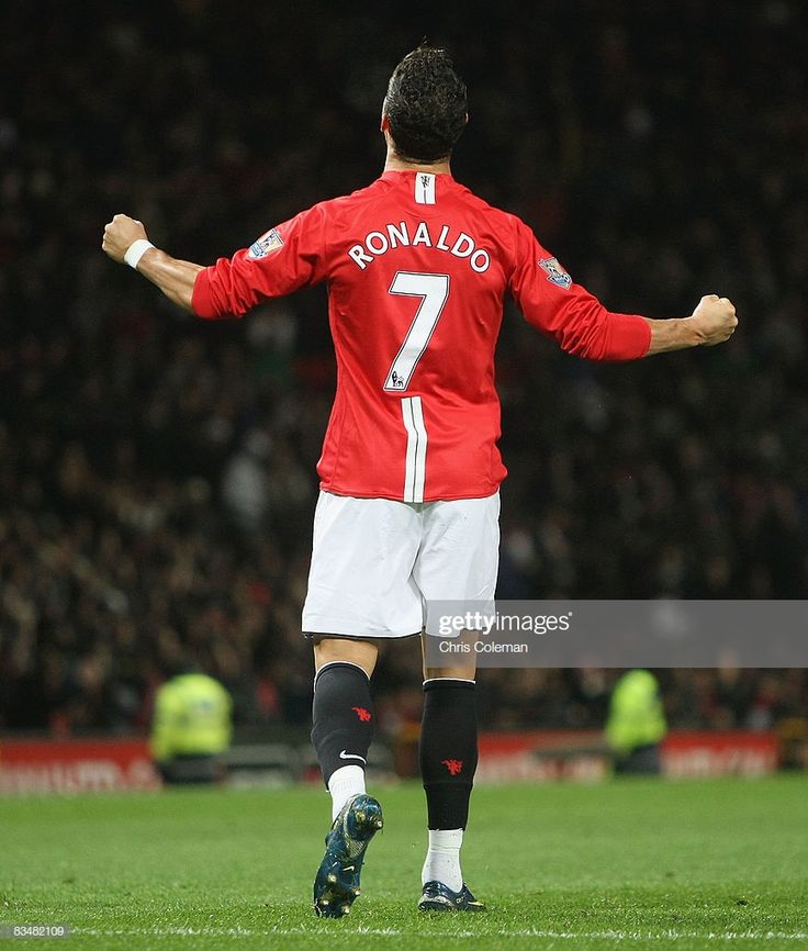 a soccer player is standing on the field with his arms out and hands in the air