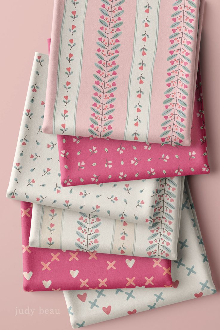 four pink and white fabric pieces on top of each other, with hearts in the middle