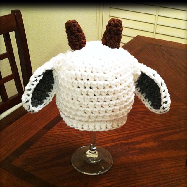 a crocheted hat sitting on top of a wooden table