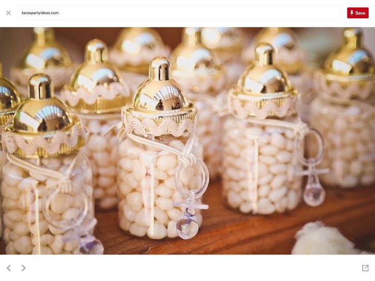 small glass jars filled with white candies on top of a wooden table next to other items