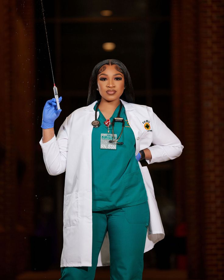 a woman wearing scrubs and holding a needle in one hand while standing on a stage