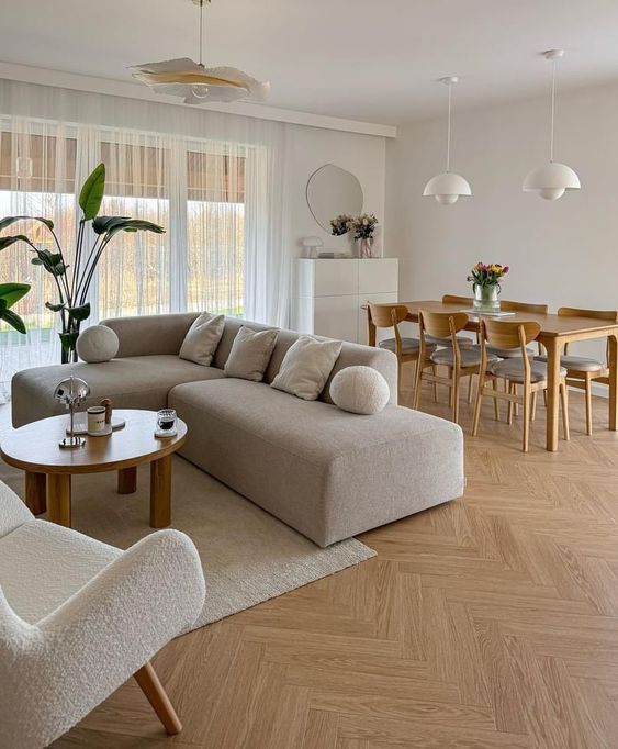 a living room filled with furniture next to a wooden table and chairs on top of a hard wood floor