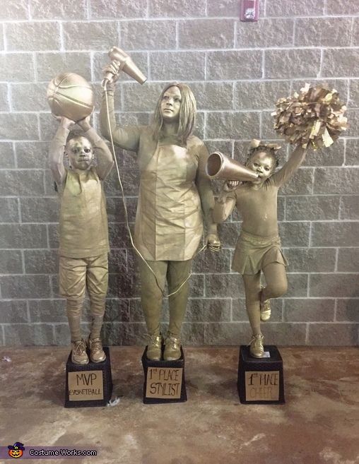 three statues of women with hair dryers and cats on their heads are posed in front of a brick wall