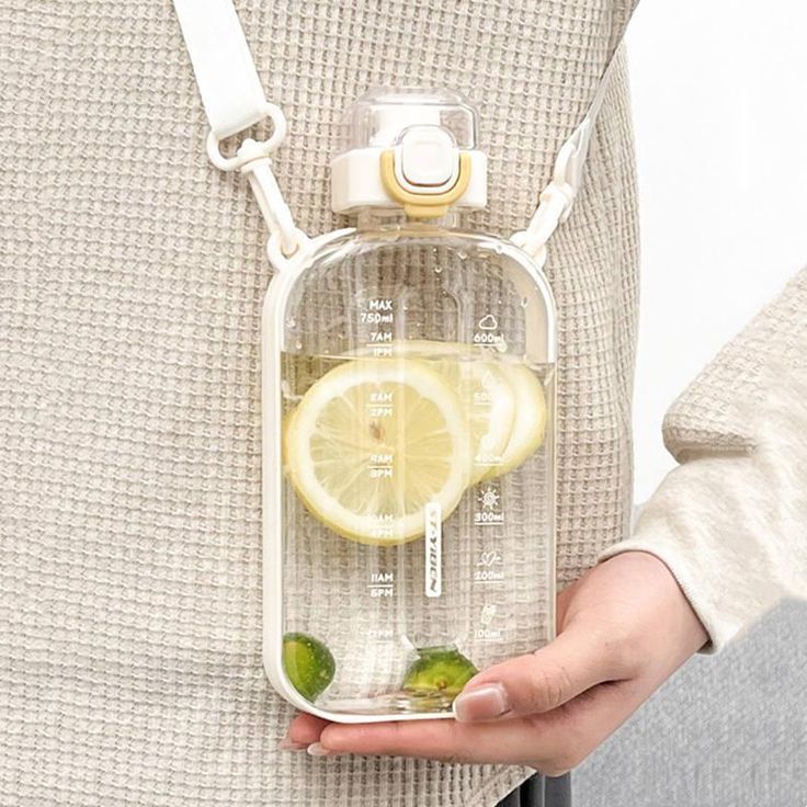 a person holding a water bottle with lemons and limes in it on their belt