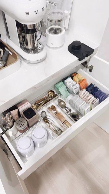 an open drawer in a kitchen filled with items