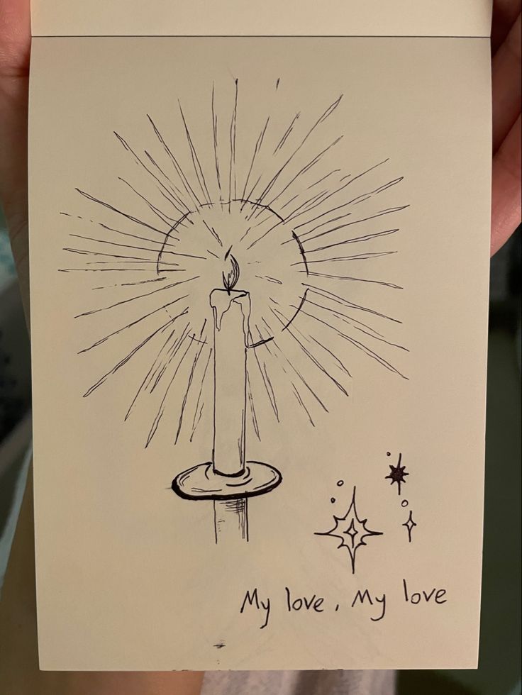 someone holding up a card with a drawing of a lit candle on it and the words my love, my love