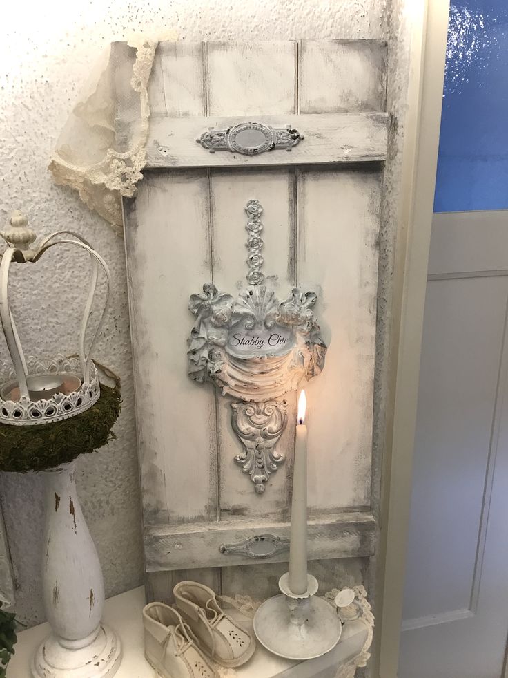 a candle is lit in front of an old cabinet with shoes on it and other items