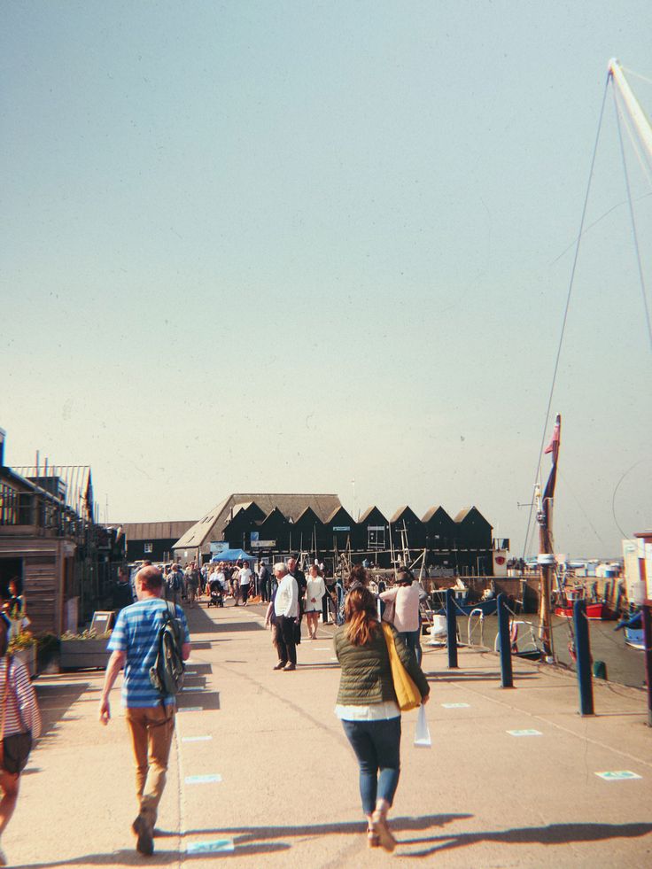 people are walking on the boardwalk at an amusement park