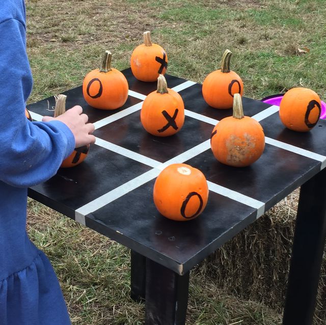 a child is playing with pumpkins that spell out the word x on a table