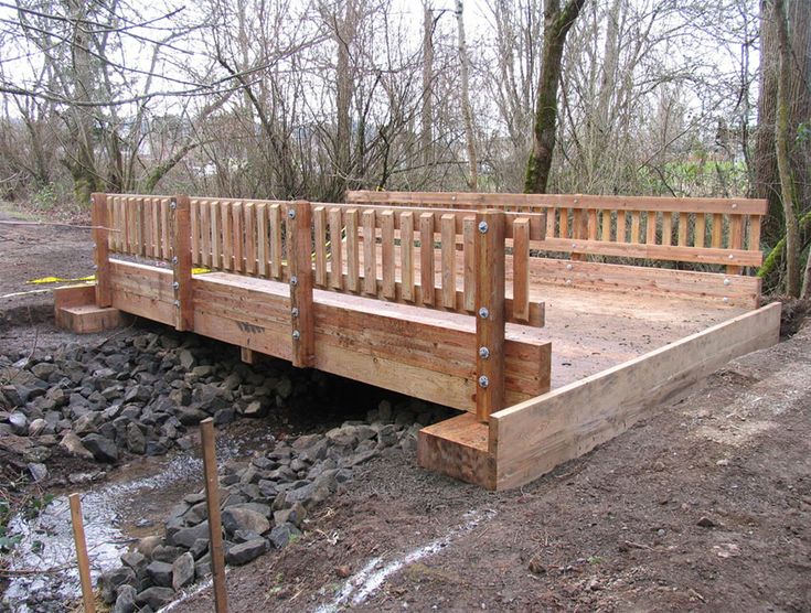 a wooden bridge over a stream in the woods