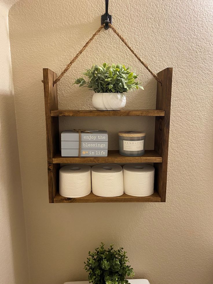 a bathroom with a toilet and shelf above it