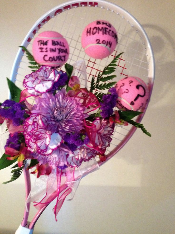 a tennis racket decorated with flowers and two balls that say the ball is in my heart