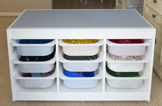 a kitchen island with plastic containers and bins