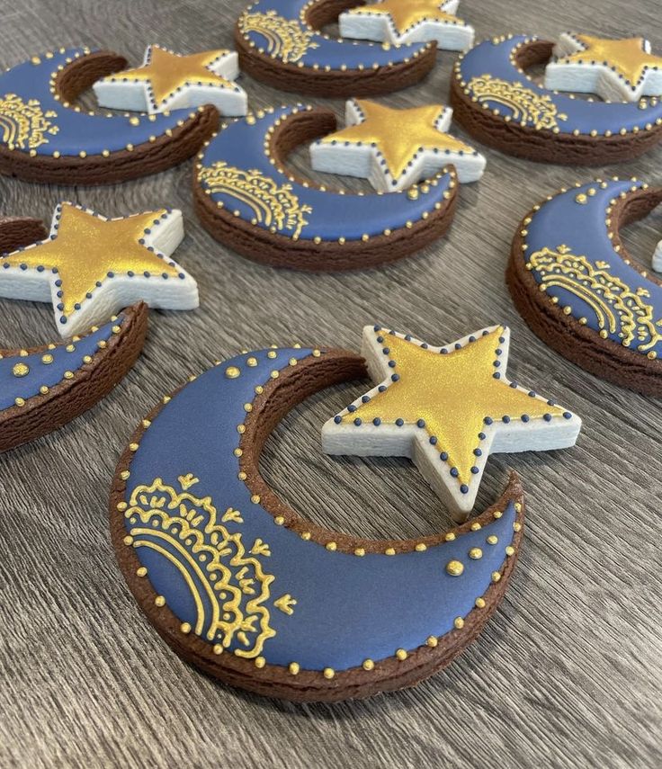 decorated cookies arranged in the shape of crescents, stars and moon on a table