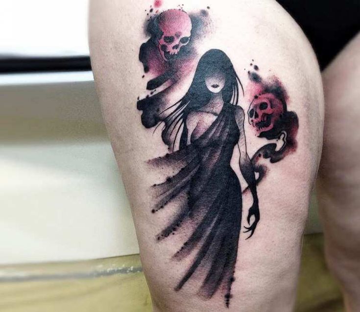 a woman with a skull tattoo on her thigh holding a rose and two skulls in the background