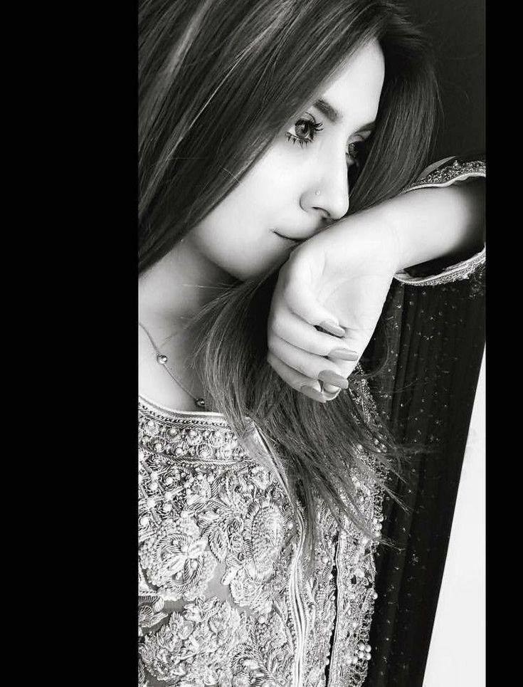 black and white photograph of a woman with long hair holding her hand on her shoulder