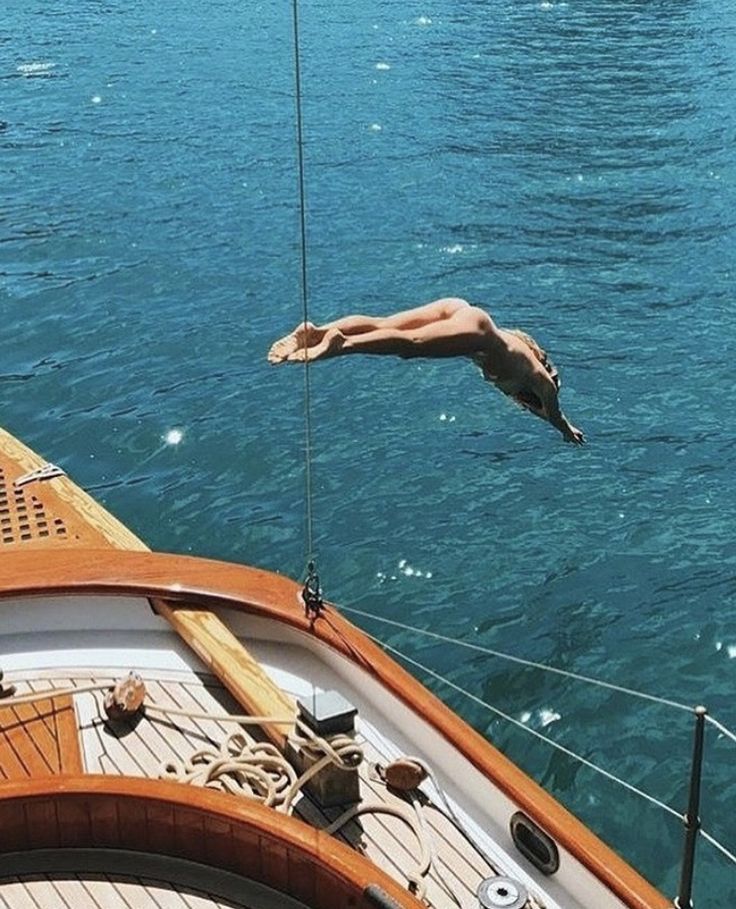 a man diving into the water from a boat