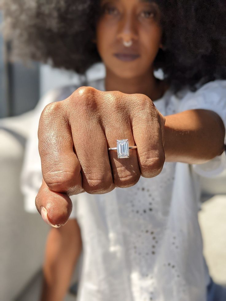 a close up of a person pointing at the camera with a ring on their finger