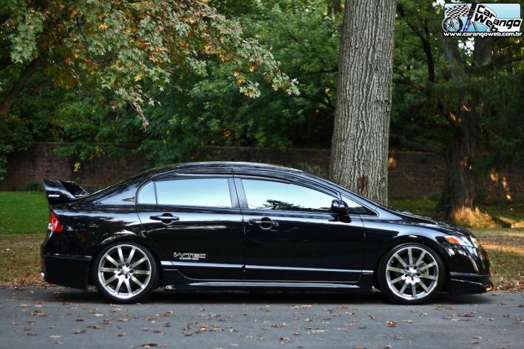 a black car parked in front of a tree