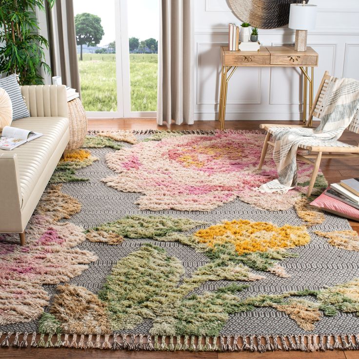 a living room with a couch, chair and rug on the floor in front of a window