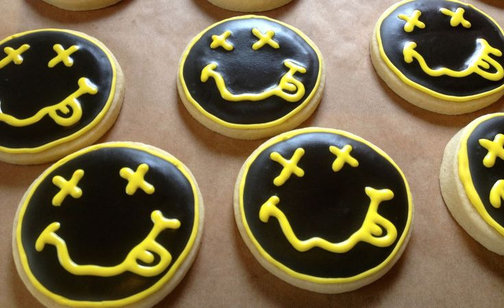 decorated cookies with black and yellow icing are arranged in a circle on a table