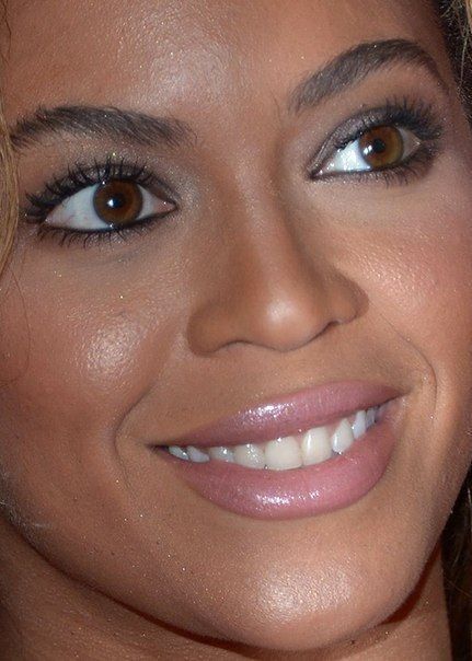 a close up photo of a woman smiling for the camera