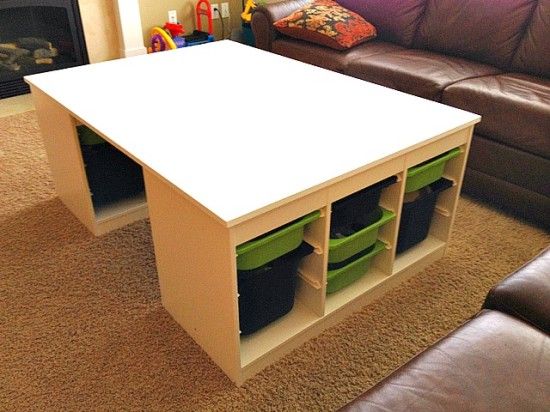 a living room with a couch, coffee table and storage bins