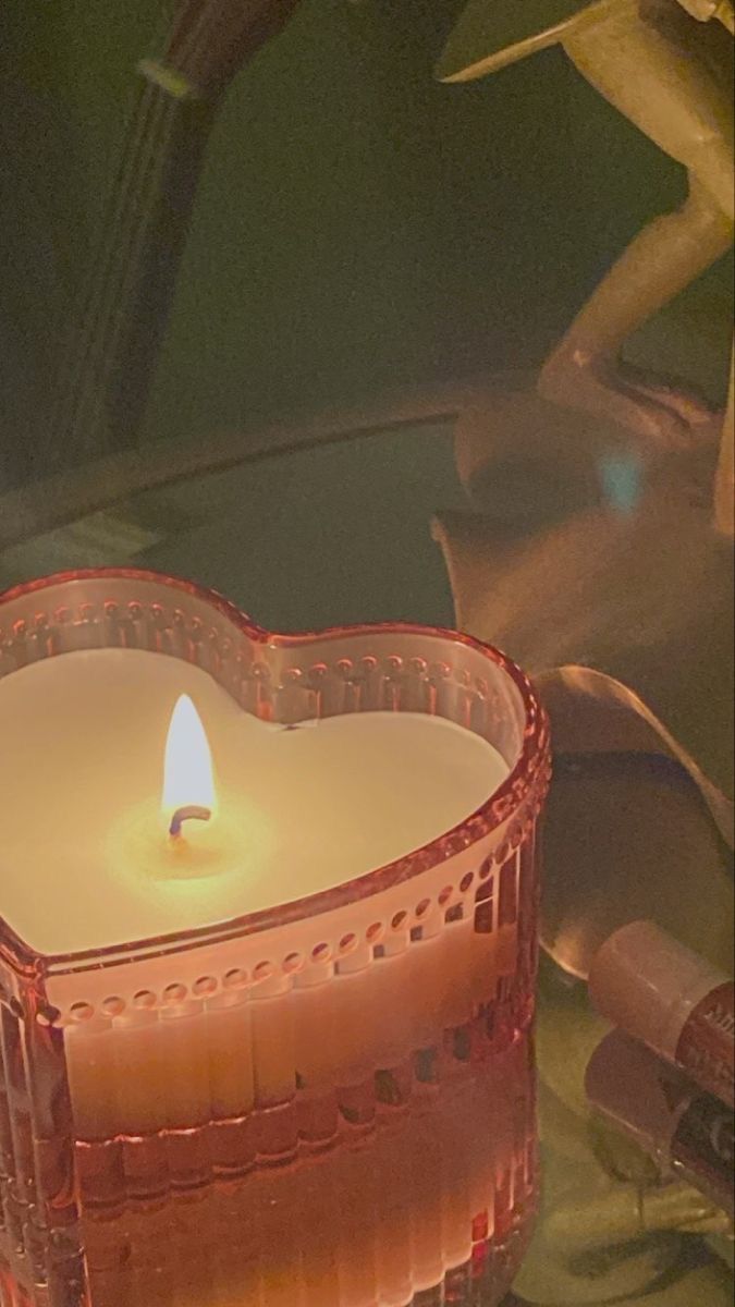 a heart shaped candle sitting on top of a table