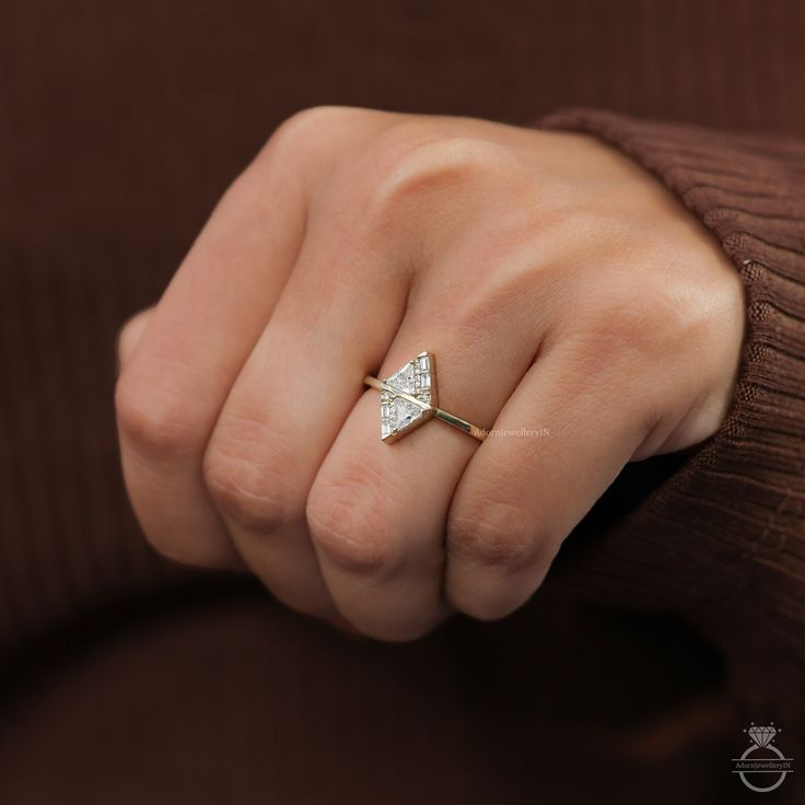 a woman's hand with a diamond ring on her left wrist, wearing a brown sweater