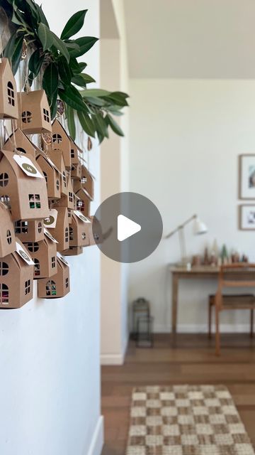 a bunch of cardboard houses hanging from the side of a wall