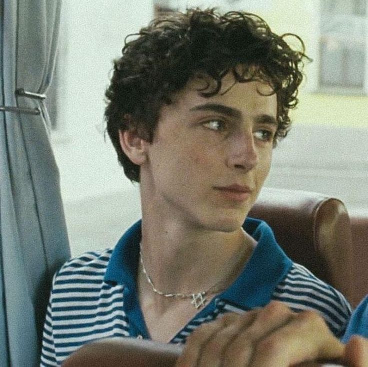 a young man sitting in the back seat of a car